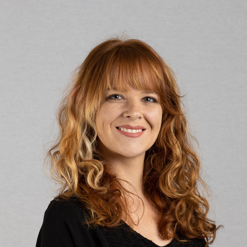 Actor headshot of a woman with long red curly hair