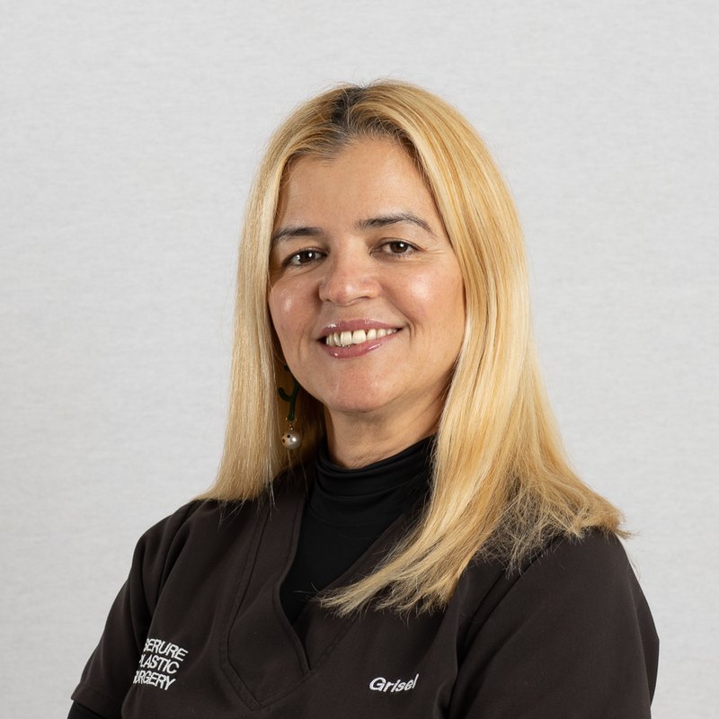 Medical headshot of a smiling clinical staff member in black scrubs